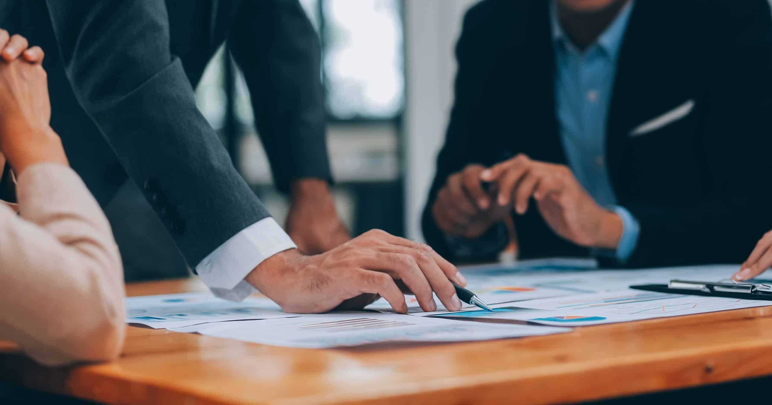 Réunion d'affaires avec documents sur une table.